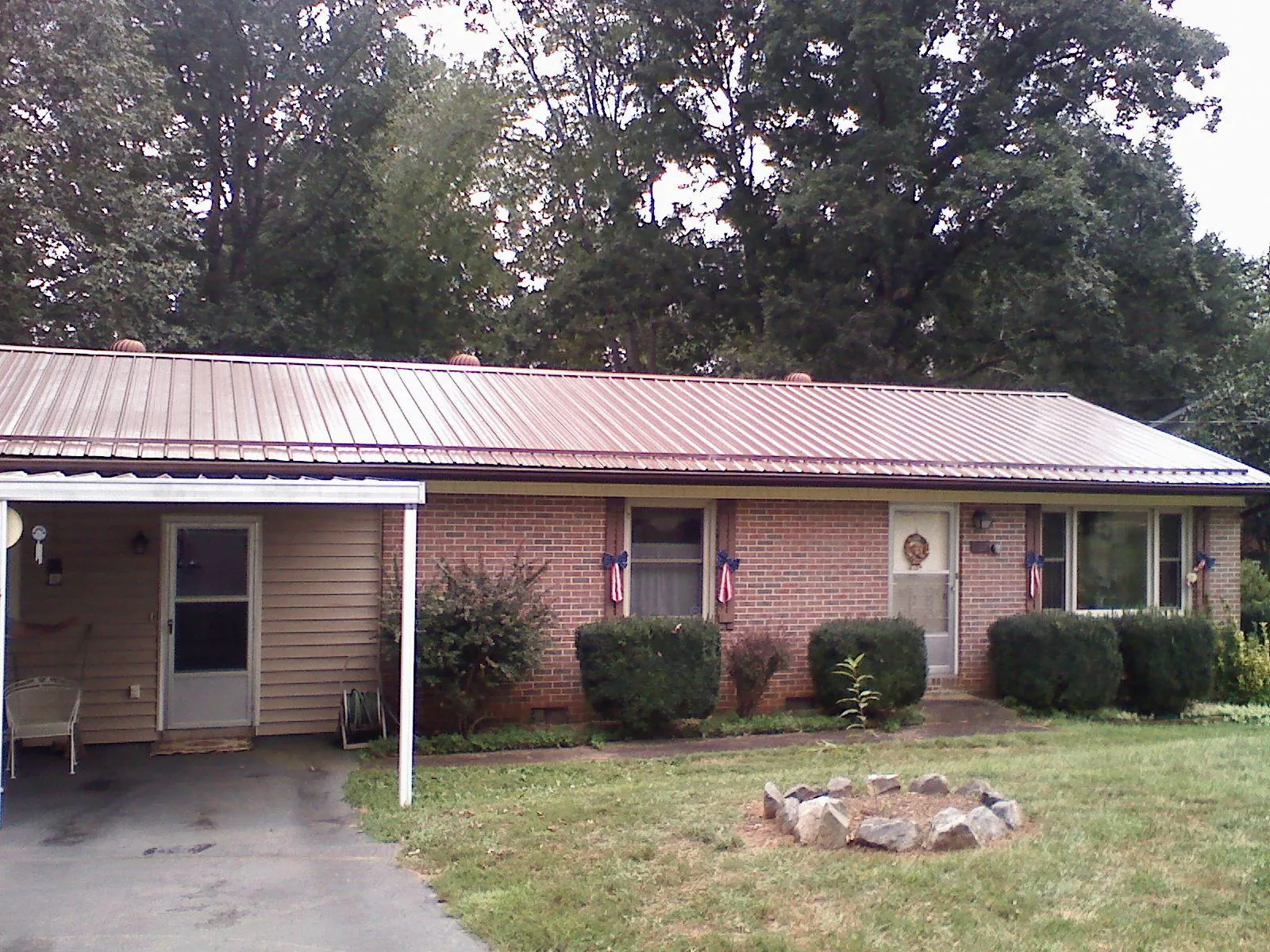 Bronze metal roof and carport on a brick ranch home — Roof Repair work by our crew in Belt